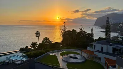 a sunset over the ocean with a building at The Venus Apartment By Sam Houses in Funchal