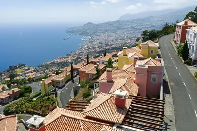 a balcony with a chair and a view of the ocean at Luxury Villa Pembe Palheiro Village by Holiday Rental Madeira in Funchal