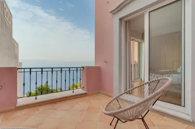 a large kitchen with white cabinets and a table at Luxury Villa Pembe Palheiro Village by Holiday Rental Madeira in Funchal