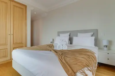 a bedroom with a white bed with a large window at Luxury Villa Pembe Palheiro Village by Holiday Rental Madeira in Funchal