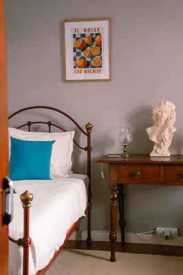 a bedroom with a bed and a table with a picture on the wall at Casa d'Avo - 3BD cosy home in Funchal
