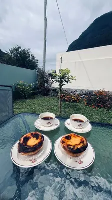 a room with a table and a kitchen with a bed at Pousada Teixeira 11C in São Vicente