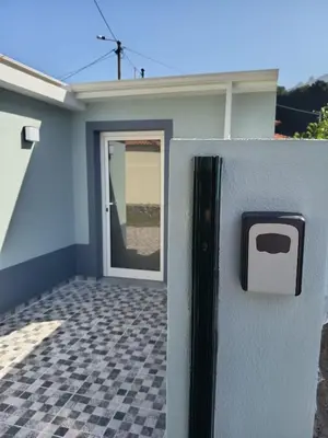 a stone wall with a clock on it next to a door at Pousada Teixeira 11C in São Vicente