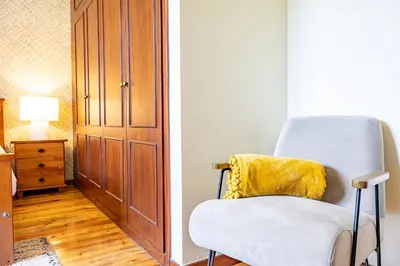a white chair with a yellow pillow in a room at Casa Golino by YOUR KEY in São Vicente