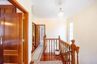 a hallway with a wooden staircase and a door at Casa Golino by YOUR KEY in São Vicente