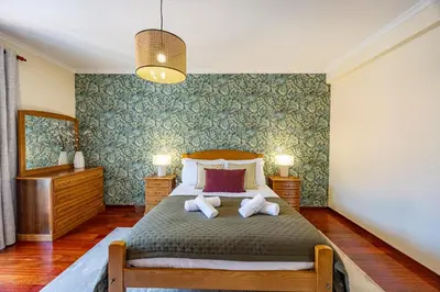 a bedroom with a large bed with two pillows at Casa Golino by YOUR KEY in São Vicente