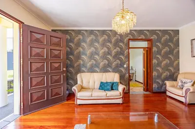 a living room with two chairs and a sliding door at Casa Golino by YOUR KEY in São Vicente
