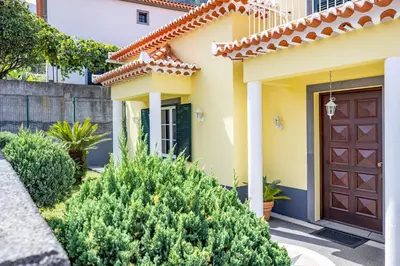 a house with a brown door and some bushes at Casa Golino by YOUR KEY in São Vicente