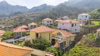 a group of houses on a hill with mountains in the background at Casa Golino by YOUR KEY in São Vicente