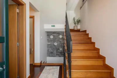 a staircase in a house with a stone wall at Casa Jardim Celeste in Seixal