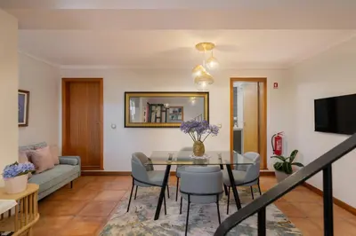 a living room with a table and chairs at Casa Jardim Celeste in Seixal
