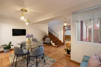 a living room with a glass table and chairs at Casa Jardim Celeste in Seixal