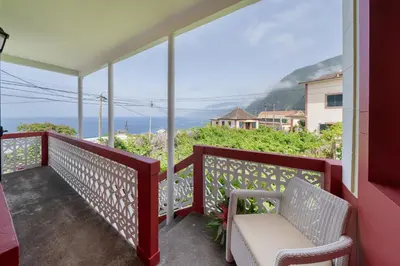 a balcony with two chairs and a view of the ocean at Casa Jardim Celeste in Seixal