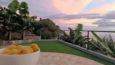 a bowl of fruit sitting on a table on a balcony at Amendoeira House - House in Ponta do Sol in Ponta do Sol