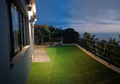 a balcony with green grass on the side of a house at Amendoeira House - House in Ponta do Sol in Ponta do Sol