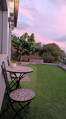 a patio with a table and chairs on a lawn at Amendoeira House - House in Ponta do Sol in Ponta do Sol
