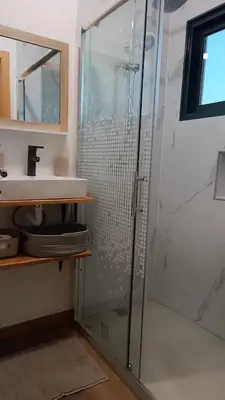 a bathroom with a glass shower and a sink at Amendoeira House - House in Ponta do Sol in Ponta do Sol