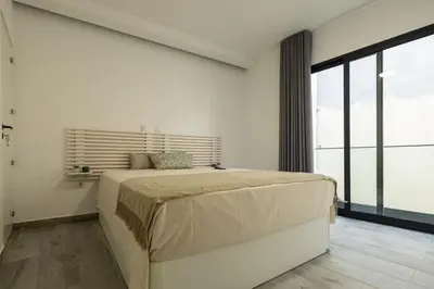a bedroom with a large bed and a large window at No Stress House in Paul do Mar