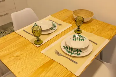 a wooden table with plates and utensils on it at No Stress House in Paul do Mar