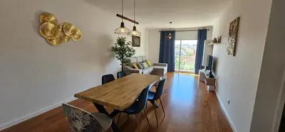 a living room with a wooden table and chairs at Achada View by Rentallido in Funchal
