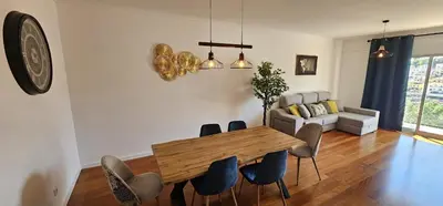 a living room with a wooden table and chairs at Achada View by Rentallido in Funchal