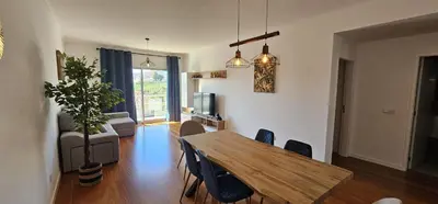 a living room with a wooden table and chairs at Achada View by Rentallido in Funchal