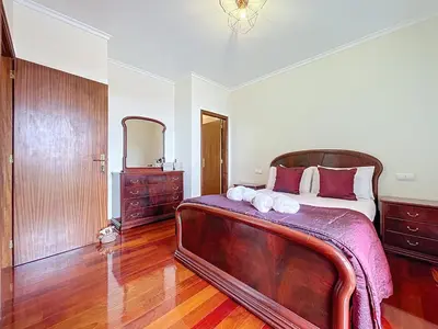 a bedroom with a large bed and wooden floors at Gaula Family Haven by Atlantic Holiday in Gaula