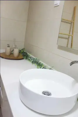 a white bathroom sink with two candles on a counter at Mocha House in Machico