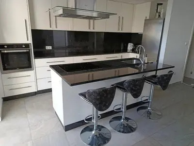 a kitchen with a stove and a counter with stools at A Casa do Encanto da Ana & Luis in Ponta do Sol