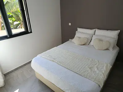 a bedroom with a bed with two pillows and a window at A Casa do Encanto da Ana & Luis in Ponta do Sol