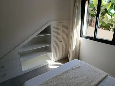 a room with a staircase with white shelves and a window at A Casa do Encanto da Ana & Luis in Ponta do Sol