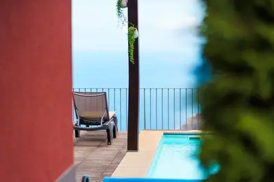 a chair sitting next to a swimming pool on a balcony at GuestReady - Exquisite stay with sea views in Calheta