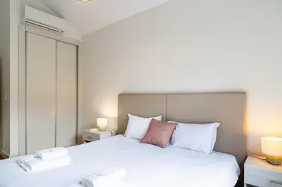 a bedroom with a large white bed with two lamps at GuestReady - Exquisite stay with sea views in Calheta