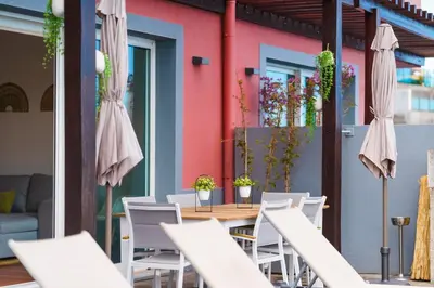 a patio with a table and chairs and a pink wall at GuestReady - Exquisite stay with sea views in Calheta
