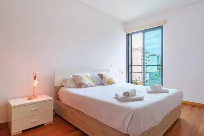 a white bedroom with a bed with towels on it at GuestReady - Modern space close to Formosa Beach in Funchal