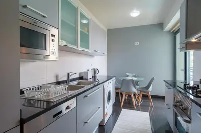 a kitchen with a sink and a microwave at GuestReady - Modern space close to Formosa Beach in Funchal