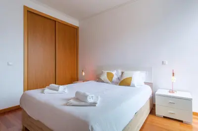 a bedroom with a large white bed with towels on it at GuestReady - Modern space close to Formosa Beach in Funchal