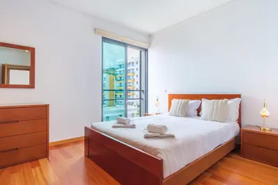 a bedroom with a large bed and a large window at GuestReady - Modern space close to Formosa Beach in Funchal