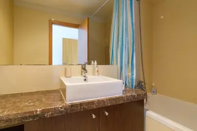 a bathroom with a white sink and a mirror at GuestReady - Modern space close to Formosa Beach in Funchal