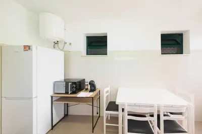 a kitchen with a white refrigerator and a table and chairs at Casa do Massapez by Mth in Santa Cruz