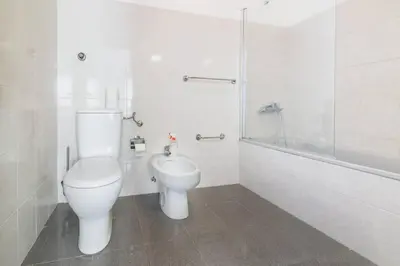 a white bathroom with a toilet and a shower at Casa do Massapez by Mth in Santa Cruz