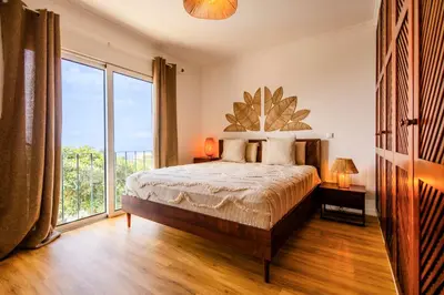a bedroom with a bed and a large window at Villa Crossdeira - A Wellness Retreat in Arco da Calheta