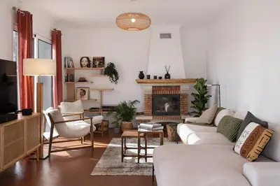 a living room with white furniture and a fireplace at Villa Crossdeira - A Wellness Retreat in Arco da Calheta