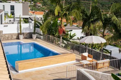 a swimming pool on the roof of a house at Villa Crossdeira - A Wellness Retreat in Arco da Calheta