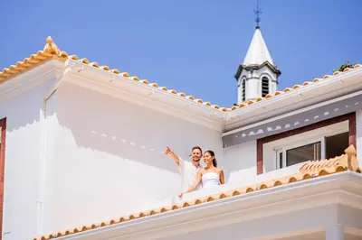 a bride and groom on the stairs of a white house at Villa Crossdeira - A Wellness Retreat in Arco da Calheta
