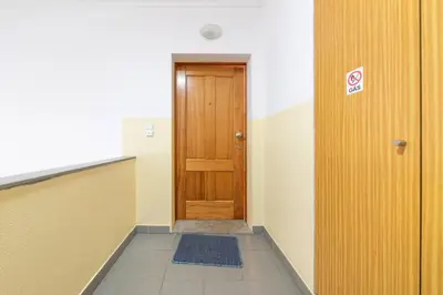 an empty hallway with a wooden door in a building at Apartamento Vieira by Mth in Campanário