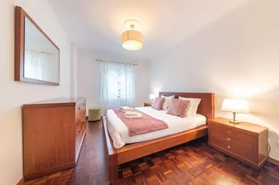a bedroom with a bed and a dresser and a mirror at Apartamento Vieira by Mth in Campanário
