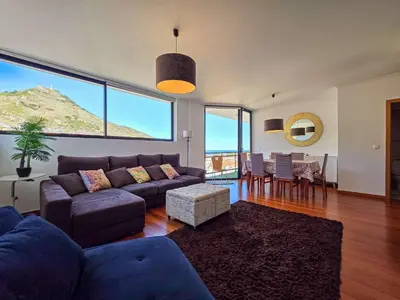 a living room with a couch and a table and chairs at Ocean View Machico in Machico