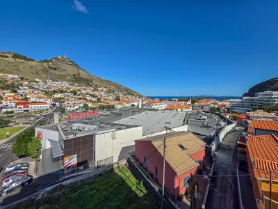 an overhead view of a city with buildings and a mountain at Ocean View Machico in Machico