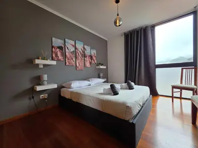 a bedroom with a bed and a large window at Ocean View Machico in Machico